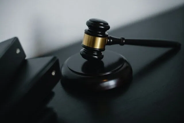 Judge's gavel on a dark wooden surface in a courtroom