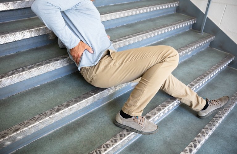 man lying on stairs after slip and fall accident