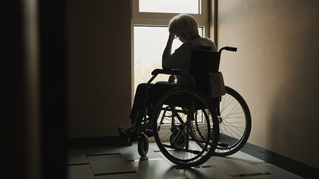Elderly Nursing Home Resident Sitting Alone In Wheelchair