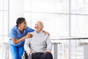 Nurse assisting an elderly nursing home resident in a wheelchair